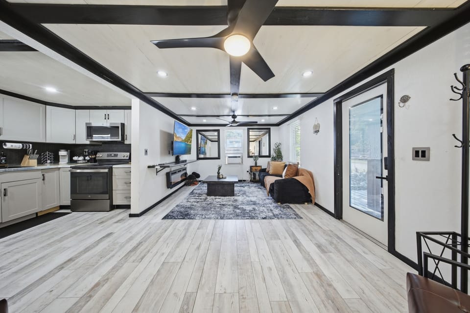 Bright open-concept living space with modern kitchen and stylish beams