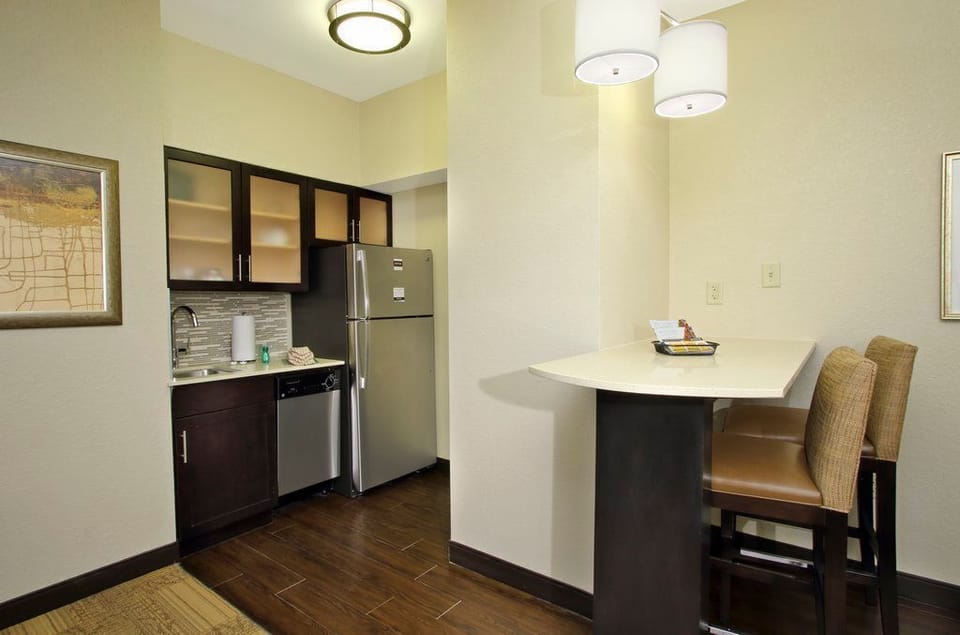 Cook your favorite meals in a modern kitchen, featuring stainless steel appliances and a convenient dining space.