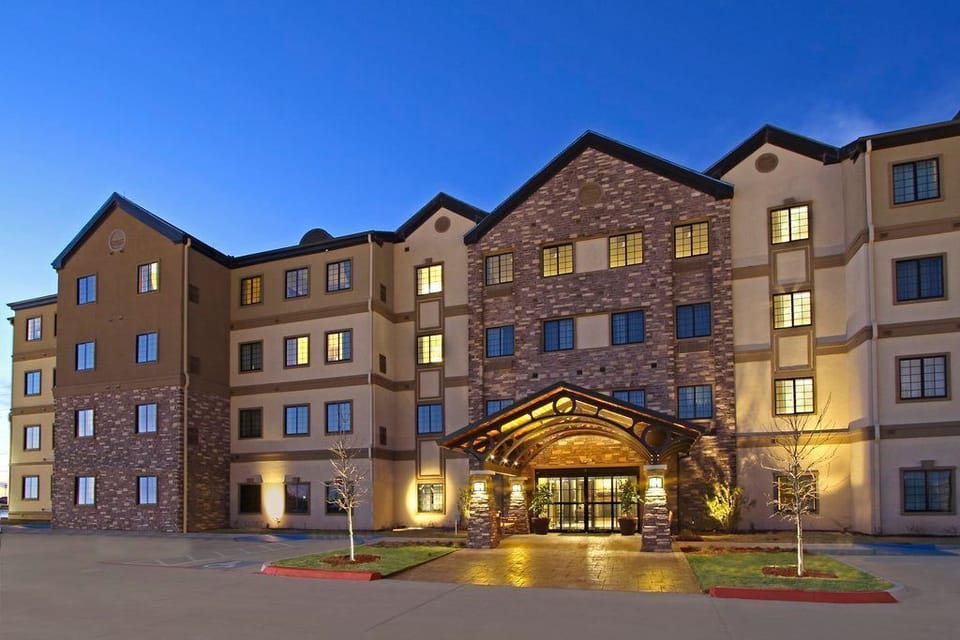 Hotel exterior with stone accents and illuminated windows at night.