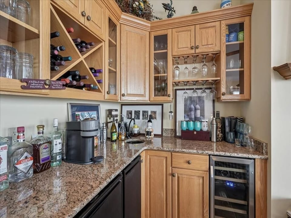 This stunning bar area features elegant wooden cabinetry and a variety of fine beverages, perfect for entertaining guests.