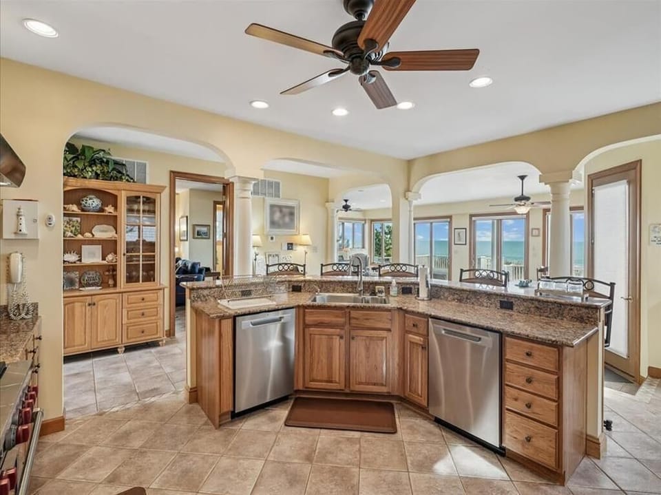 This spacious kitchen layout emphasizes convenience and style, highlighted by beautiful granite countertops and natural light flooding through large windows.