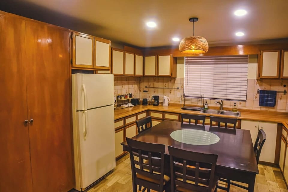 Elegant dining area with wooden table and warm lighting, perfect for meals, remote work, or relaxed conversations.