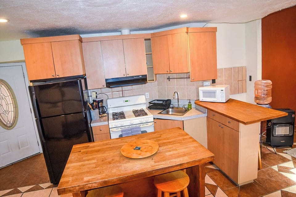 Kitchen area with fridge, stove, and coffee maker, ready for any meal preparation.