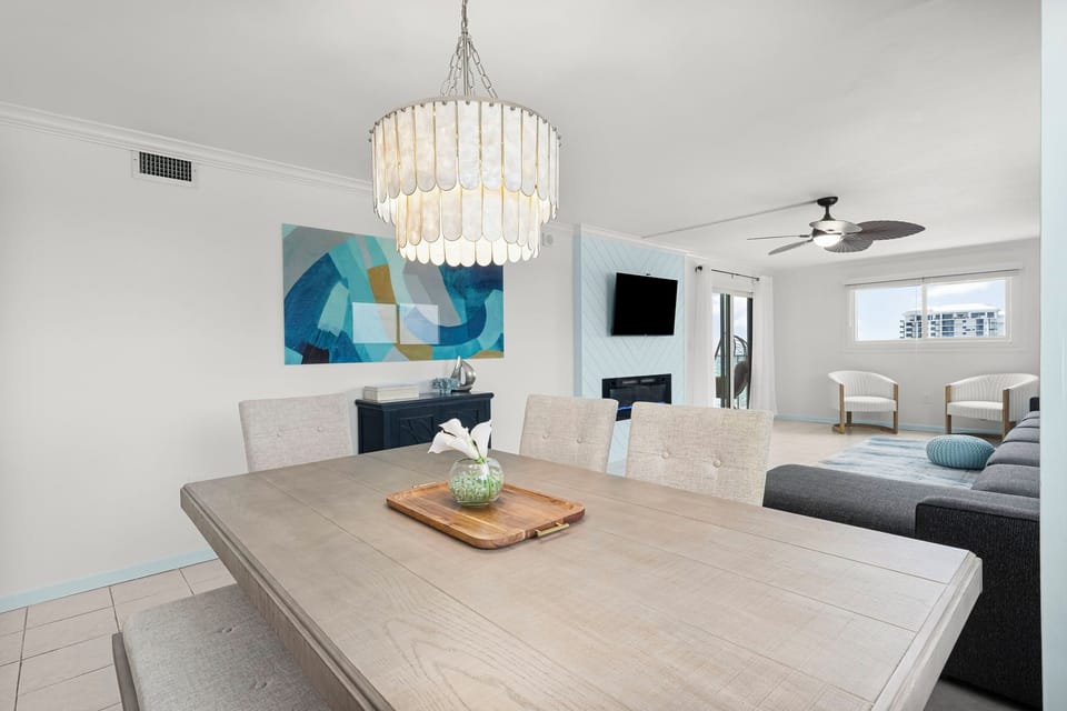 Enjoy meals with a view at this oceanfront vacation rental in Florida. This stylish dining area is perfect for family dinners or romantic evenings, with sunset views and an open layout that flows into the living room—your ideal Panama City Beach getaway.