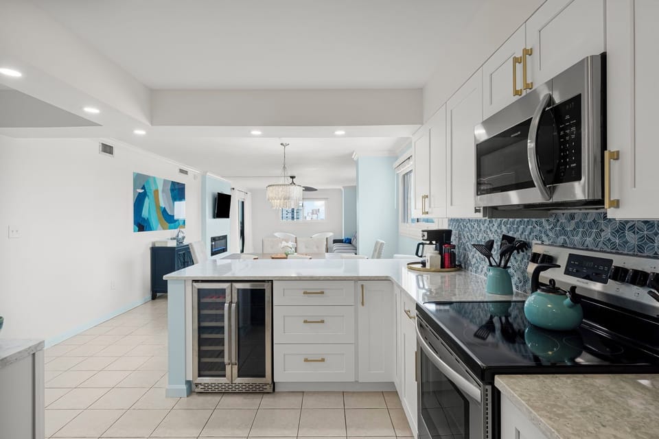 Fully stocked kitchen with stainless steel appliances, wine fridge, and spacious island—perfect for family meals or entertaining. Stay at The Breakers View by Relax and Renew Rentals and enjoy a beachside condo designed for comfort, convenience, and style.
