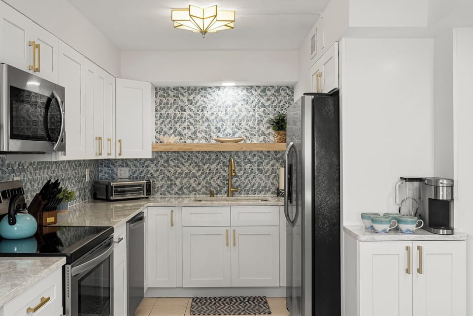 Bright and modern kitchen at The Breakers View by Relax and Renew Rentals in Panama City Beach! This beachfront condo is romantic yet family-friendly, featuring stainless appliances, Keurig coffee maker, and all essentials for meals after a beach day.