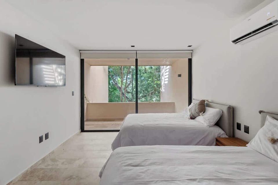 Bedroom with 2 double beds, with TV and balcony views 