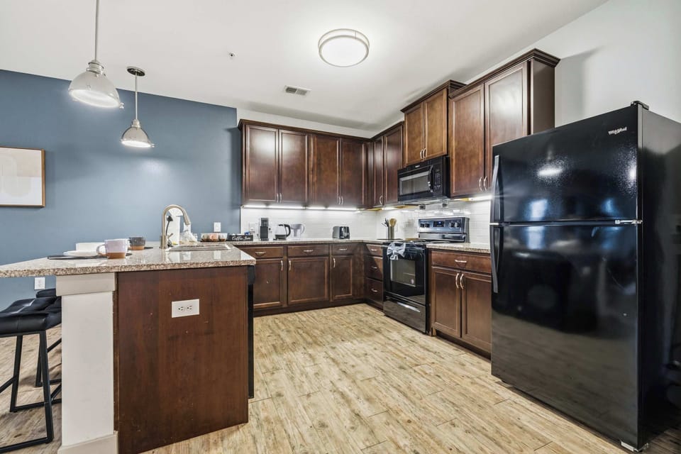 Modern kitchen with stainless steel appliances and breakfast bar.