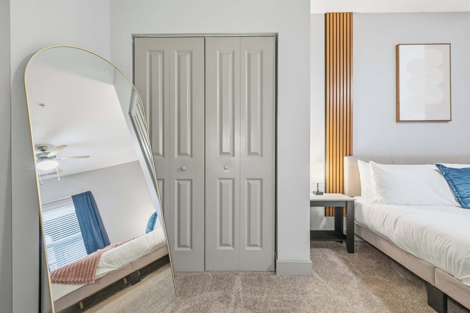 Stylish bedroom with full-length mirror and modern finishes