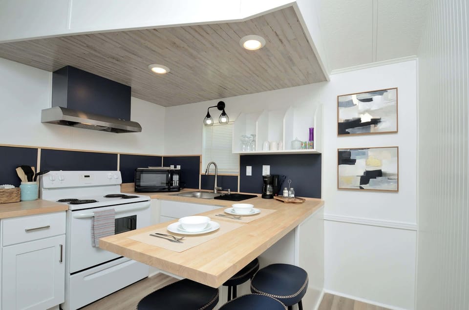 Bright kitchen w/ island seating & sleek finishes, ideal for cooking & gathering