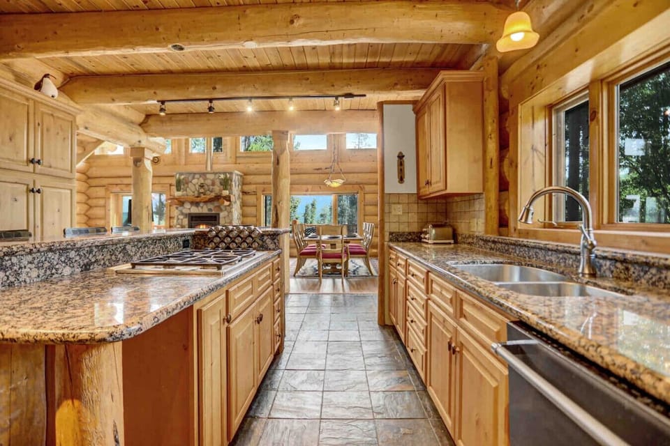 Fully functional kitchen with forest view opens up to the dining and living space