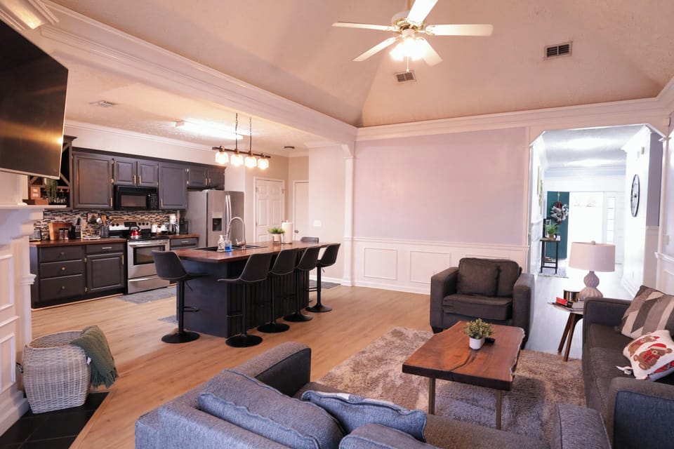Bright, cozy open living area with comfy seating, Smart TV, and kitchen island.