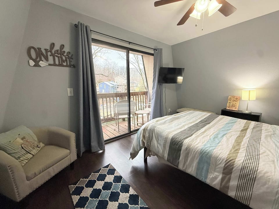 The primary bedroom boasts a queen bed, smart TV, & balcony​