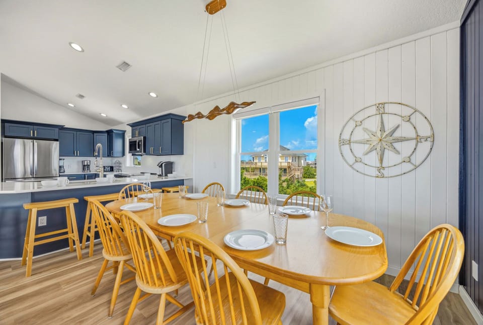 Gather around this welcoming dining table where nautical charm meets coastal comfort. Large windows frame the bright Florida sunshine, and you'll love the seamless flow into the open kitchen perfect for preparing your vacation feasts.