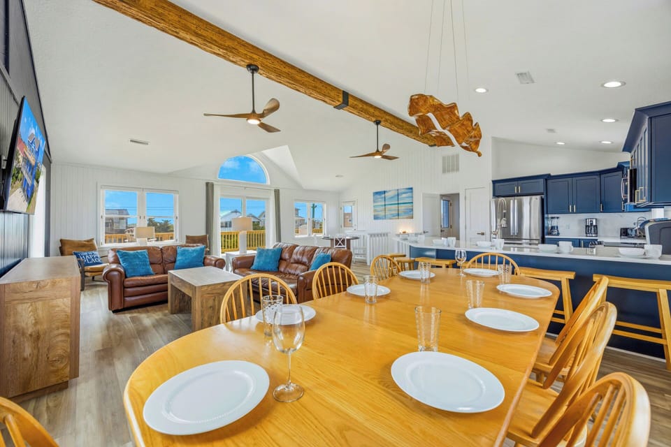 Gather around the spacious dining table, where warm wood tones and soaring vaulted ceilings create a welcoming space for your group to share meals and stories together.