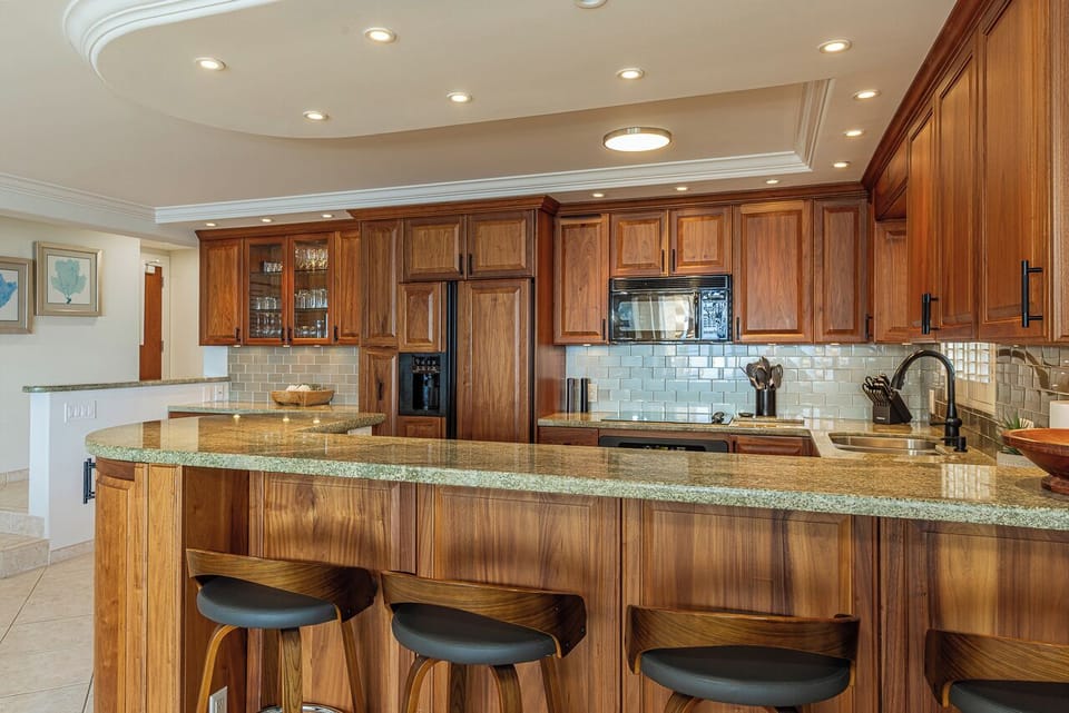 Your gourmet kitchen awaits with granite countertops, rich wood cabinetry, and modern appliances for creating memorable vacation meals.