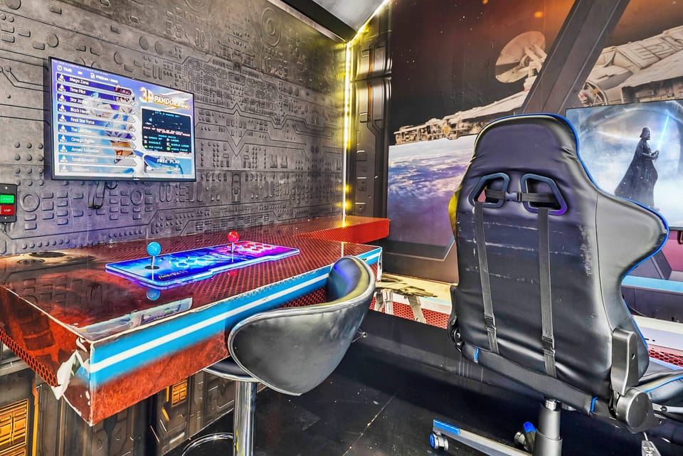 Experience a gaming paradise with a sleek illuminated desk, vibrant LED accents, and high-tech monitors. The ergonomic chair and futuristic decor create an immersive atmosphere for all tech enthusiasts and gamers to enjoy.