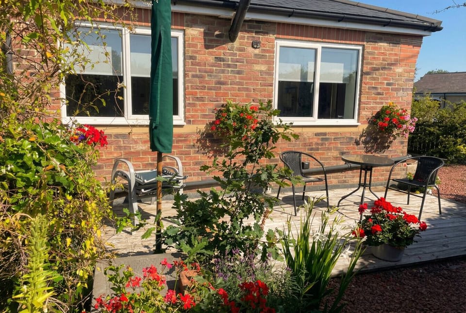 Step outside to the sunny rear patio, surrounded by flowering borders and fresh air.