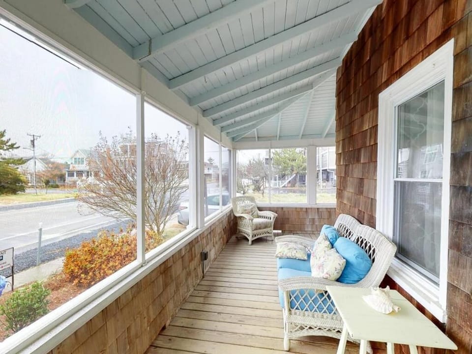 The screened porch features comfortable wicker seating, providing a cozy spot to enjoy the outdoors while being sheltered from the elements.