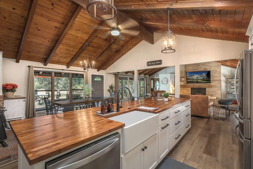 Cook in this stunning open kitchen featuring rich wood beams, gleaming countertops, and natural light streaming through large windows.