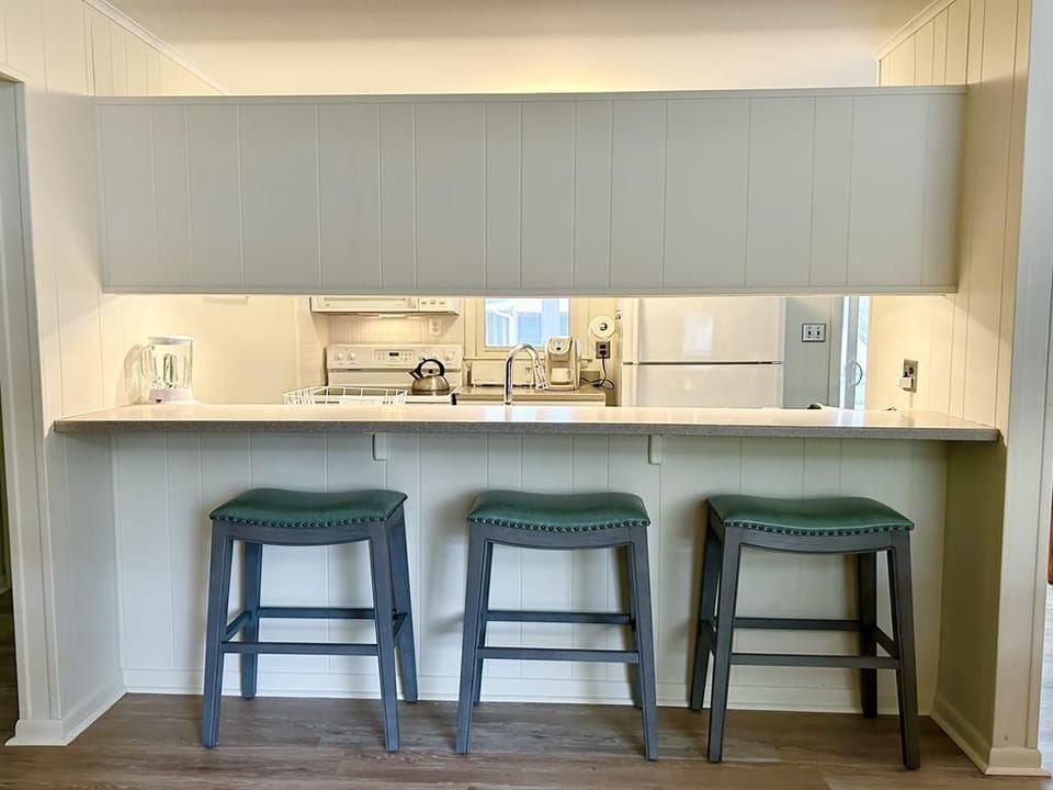 Gather at the sleek kitchen island with comfortable seating, ideal for sharing meals and laughter.