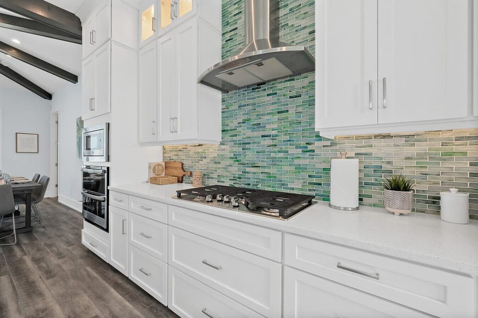 Fully equipped kitchen with stainless appliances and stylish tile backsplash