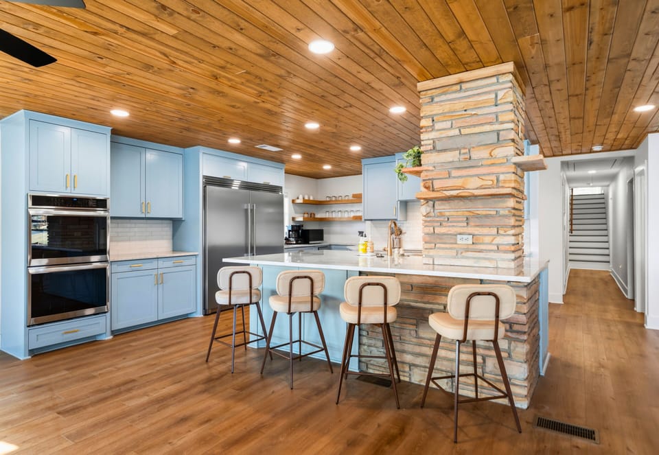 The kitchen features a long breakfast bar with seating, making it a great place for casual meals, morning coffee, or chatting with the cook while dinner comes together.