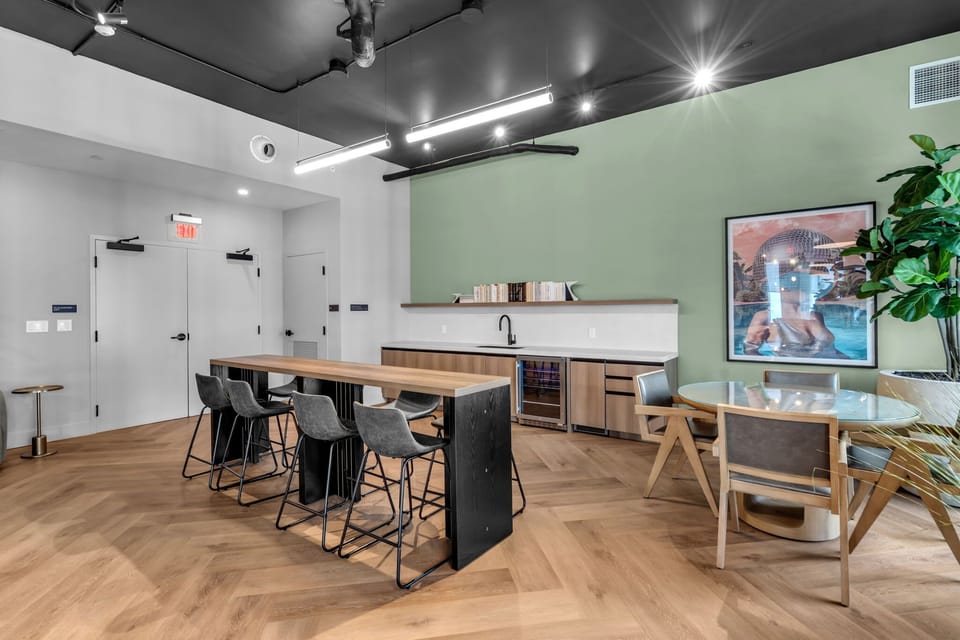 Work from anywhere in style! This modern coworking lounge features sleek high-top seating, a versatile meeting table, and a convenient refreshment station. With its chic, professional design and plenty of natural light, it is the perfect spot to stay