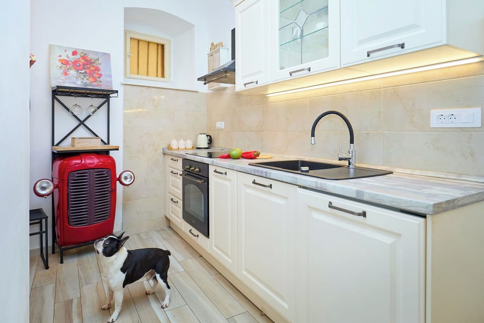 Prepare a delightful meal in the studio's fully equipped kitchen, featuring modern appliances and a clean, bright aesthetic.