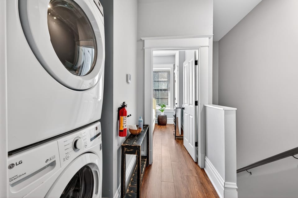 Unit A Laundry : Keep clothes fresh throughout your stay with the convenience of in-unit laundry, featuring a modern stacked front-loading washer and dryer located right off the main hallway and stairwell.