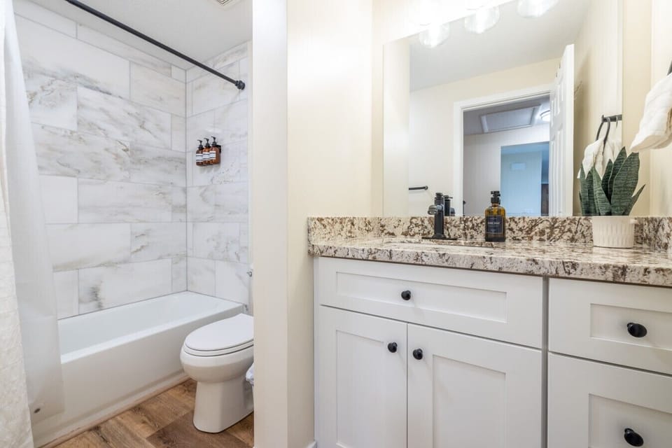 Full bathroom with granite vanity and shower tub combo