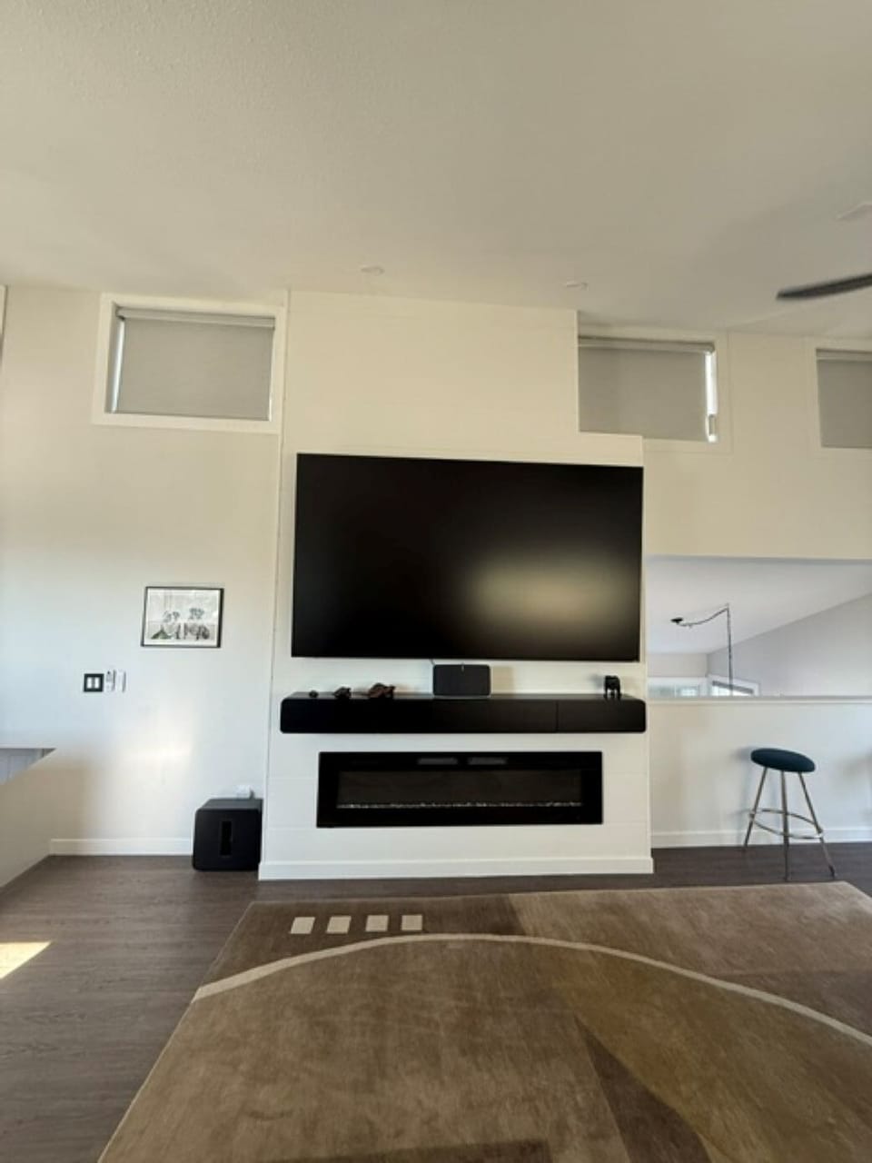 Spacious living area featuring a 100-inch TV and cozy fireplace