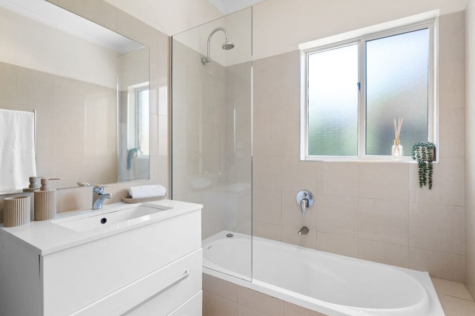 A bright bathroom with a bath and shower combo—perfect for a relaxing soak after a day out.