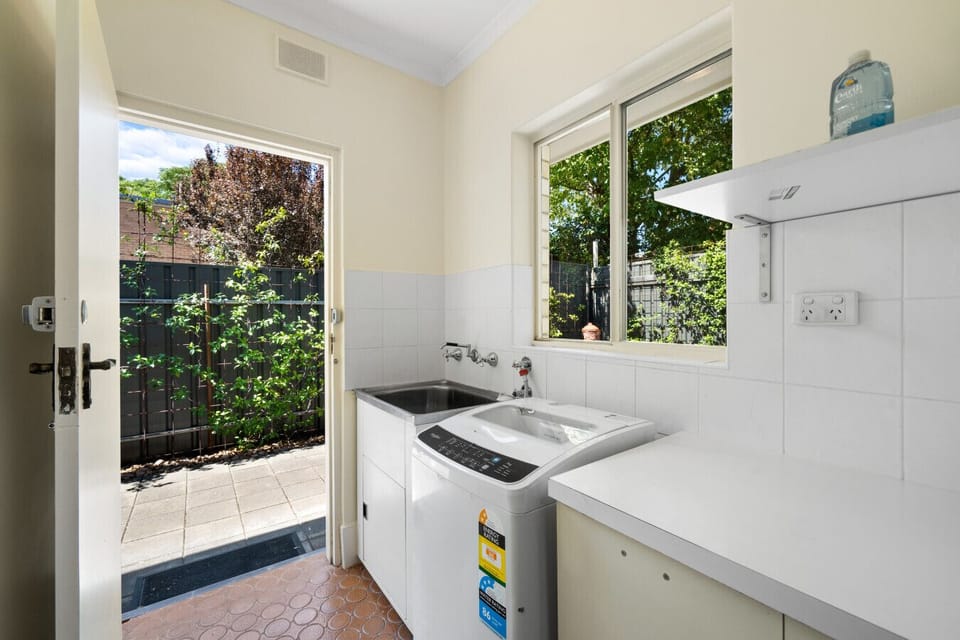 The laundry room offers a washing machine, drying racks, and a iron for guest use.