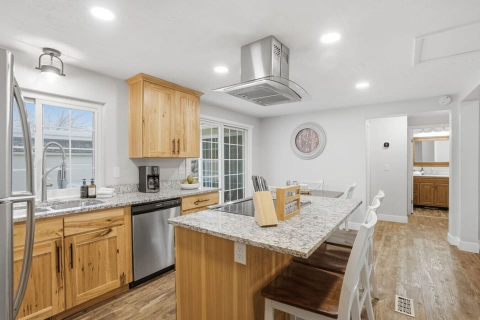 Spacious kitchen featuring granite countertops, island seating and natural light