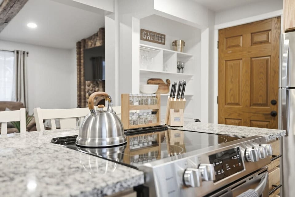 Fully equipped kitchen with island cooktop and open shelving