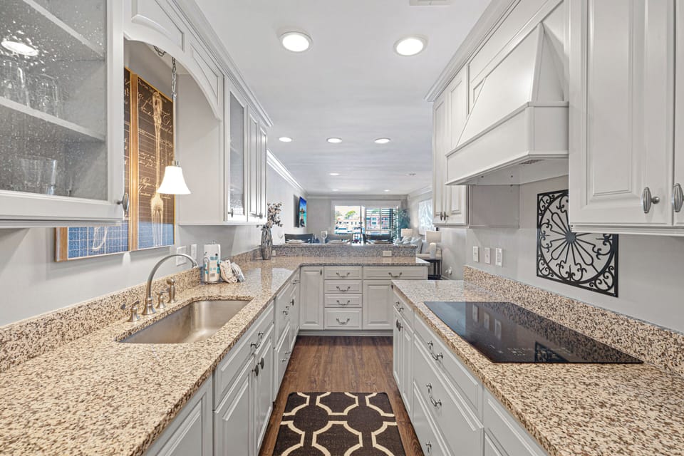 Bright cabinetry and stylish lighting add a clean, coastal feel—making it easy to enjoy everything from a quick breakfast to a relaxed evening.