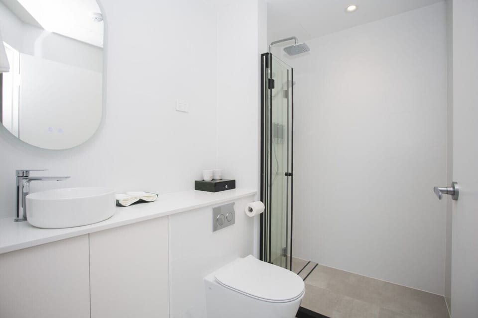 Modern private bathroom with clean finishes and essentials provided.