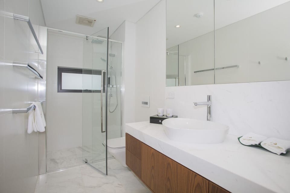 Modern private bathroom with clean finishes and essentials provided.