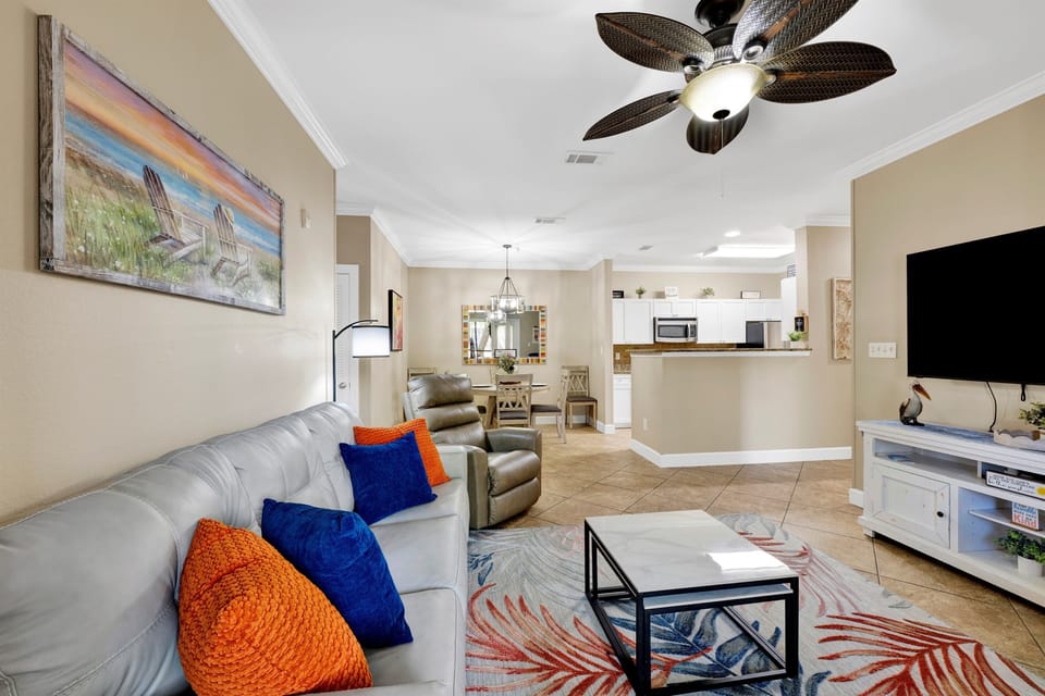 Living room with leather sleeper sofa, recliner, arm chair, ceiling fan and wall mounted smart TV 