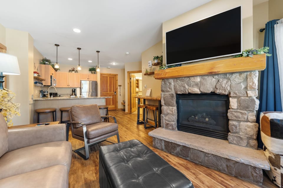 Relax by your cozy stone fireplace while enjoying the open-concept design connecting living room and fully equipped kitchen.