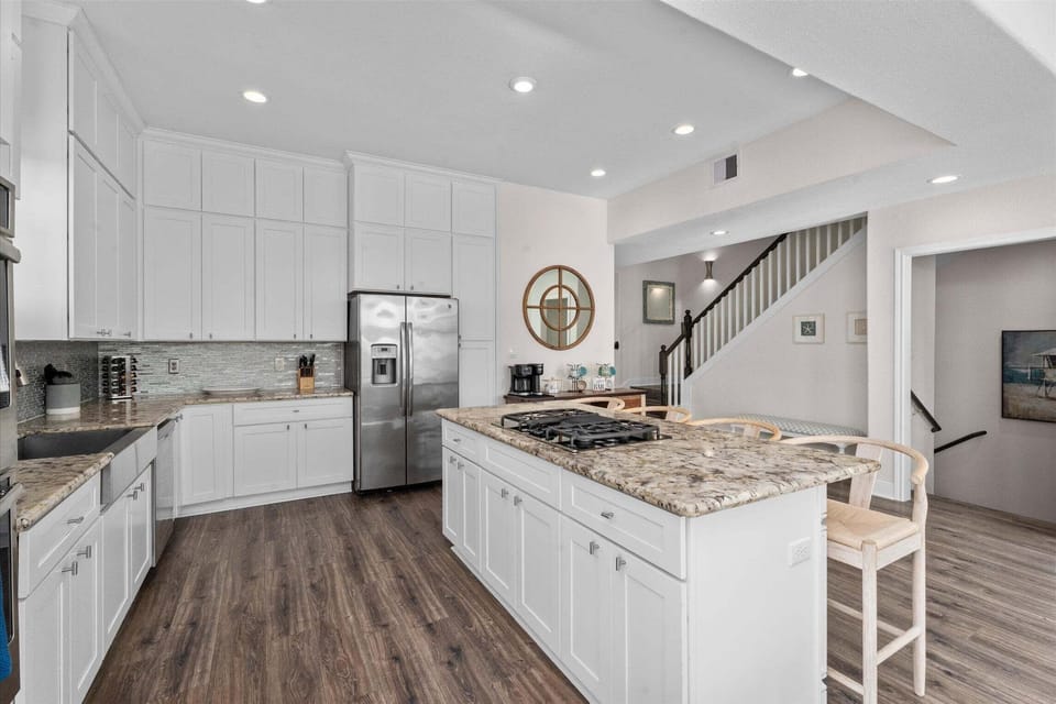 Fully equipped gourmet kitchen with stainless appliances, granite countertops, and oversized island perfect for group meals.