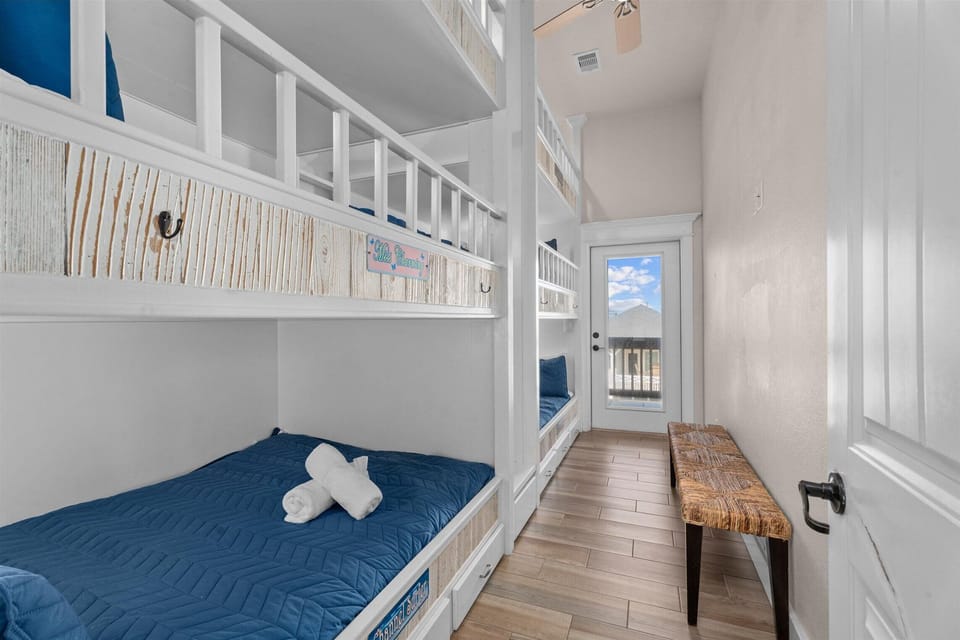 Bunk room with multiple built-in bunks and hallway access