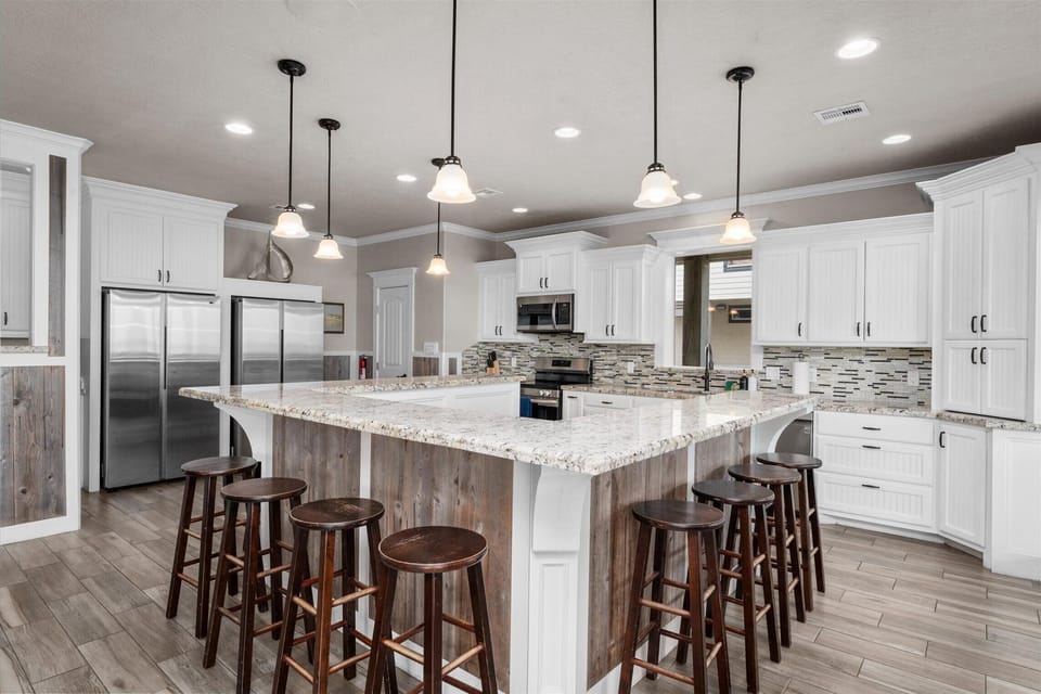 Oversized kitchen island with bar stools and open layout for entertaining