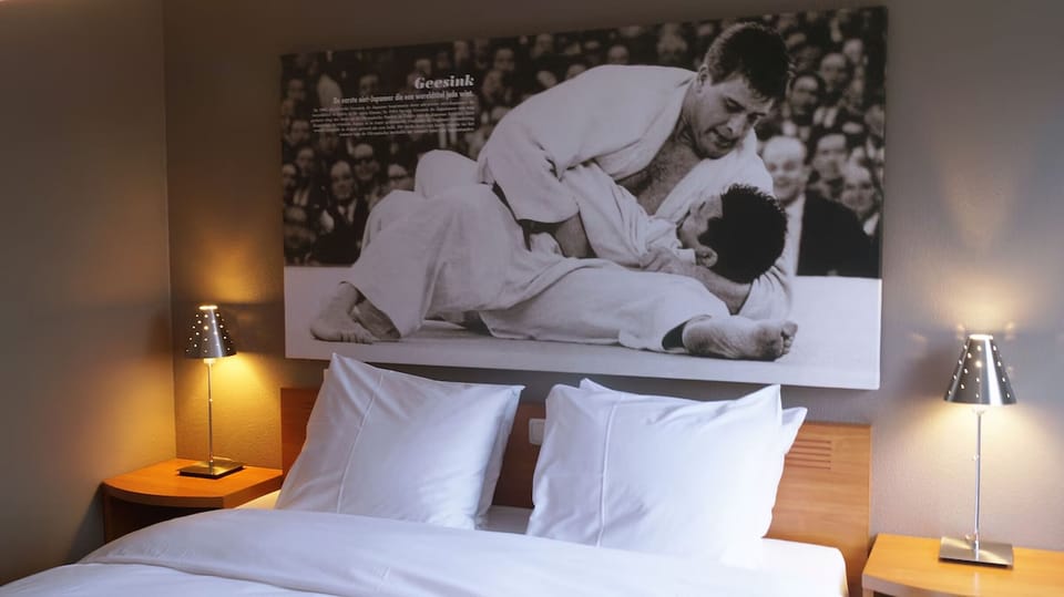 Sink into crisp linens under warm bedside glow and art.