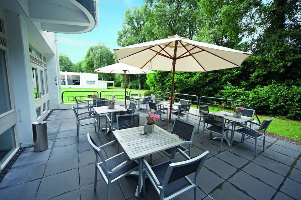 Linger outdoors with drinks under umbrellas and leafy views.