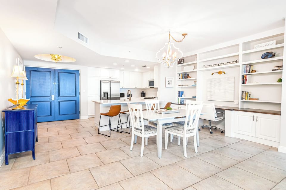 Your open-concept living space combines dining, kitchen, and work areas with coastal-inspired blue accents and built-in shelving for a seamless stay.