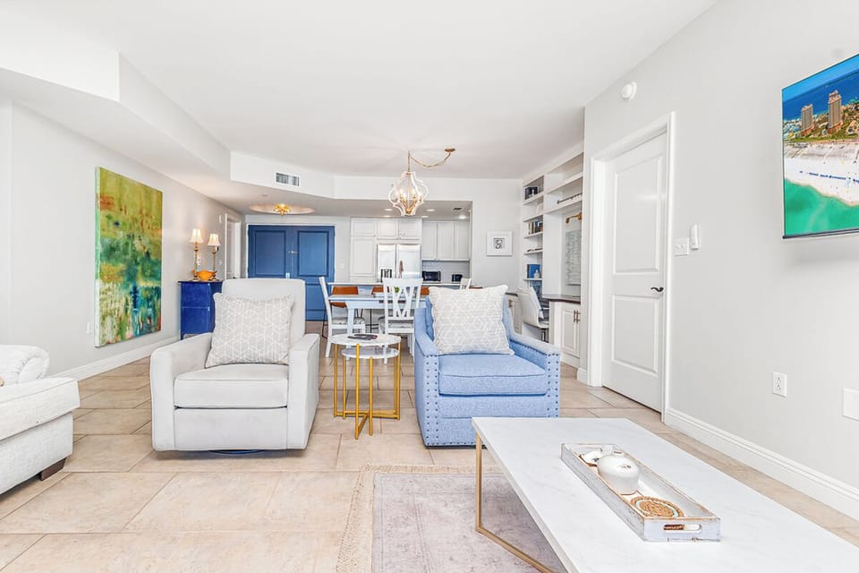 Relax in your stylish open-concept living space with modern coastal decor and fully equipped kitchen for memorable vacation meals.