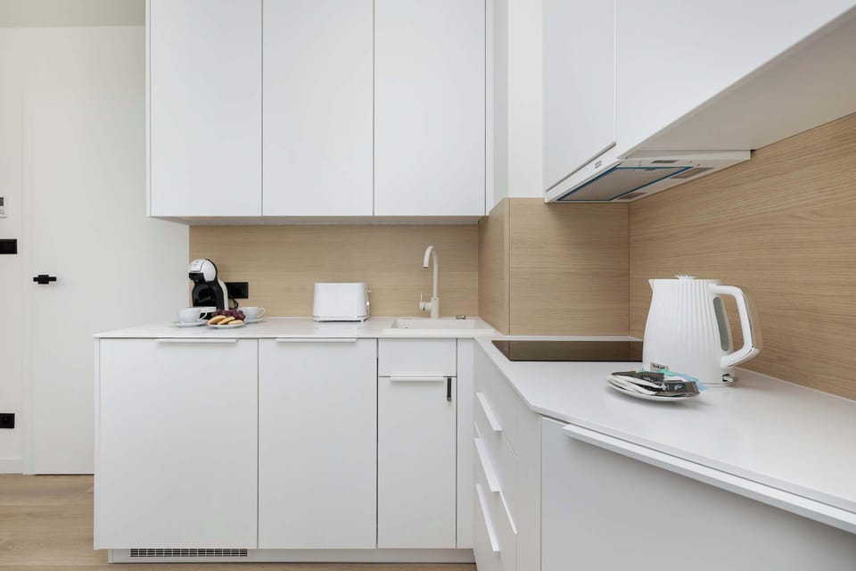 The kitchen counter holds essential appliances like a black coffee maker and a white toaster. Everything is organized to maintain a clutter-free and functional cooking environment.
