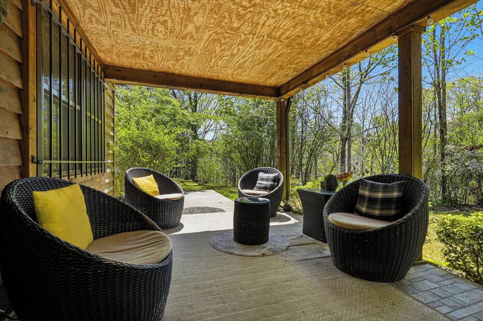 Relax in your private covered terrace surrounded by lush greenery, with comfortable wicker seating perfect for morning coffee or evening conversations.